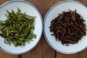 Comparaison entre des feuilles de thé vert et de thé noir infusées dans deux bols